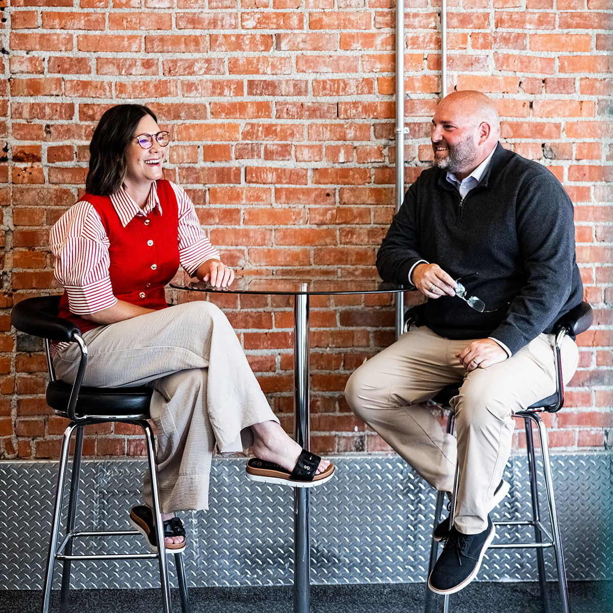 Krystle and Justin sitting at a table at the SCORR Kearney office conversing